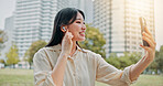 Happy, asian woman and video call with earphones in city for communication, conversation or chat. Japan, female person or talking with mobile smartphone for virtual discussion or app in an urban town