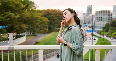 Buy stock photo Fitness, city and Asian woman with music earphones for running, outdoor training and sports routine. Exercise, podcast and Japanese female runner on bridge with radio, track and song audio in Japan