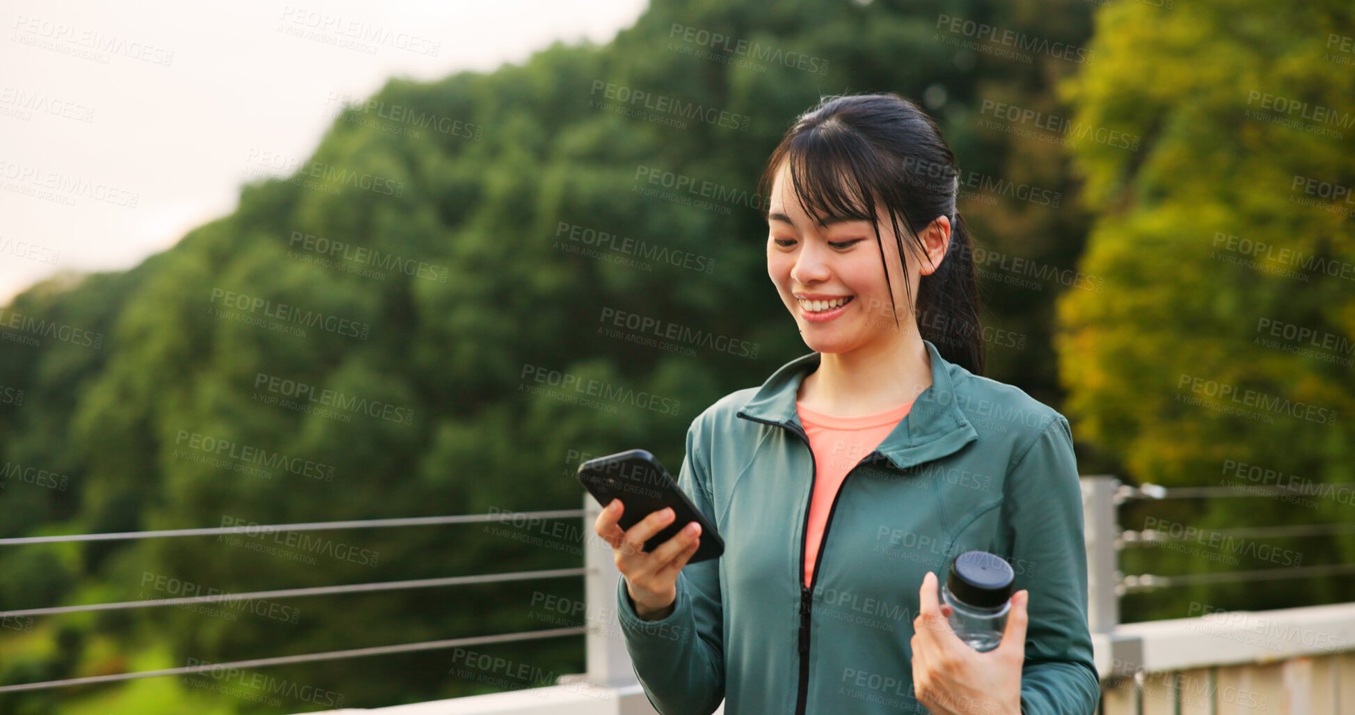 Buy stock photo Phone, sports and woman in city with online exercise plan for running, wellness and training. Happy, fitness and Japanese female athlete on cellphone with mobile health tracker app for cardio workout