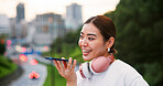 City, phone call and recording with Japanese woman outdoor for communication or voice note on bridge. Conversation, commute and headphones with happy tourist person on bridge in Japan for travel