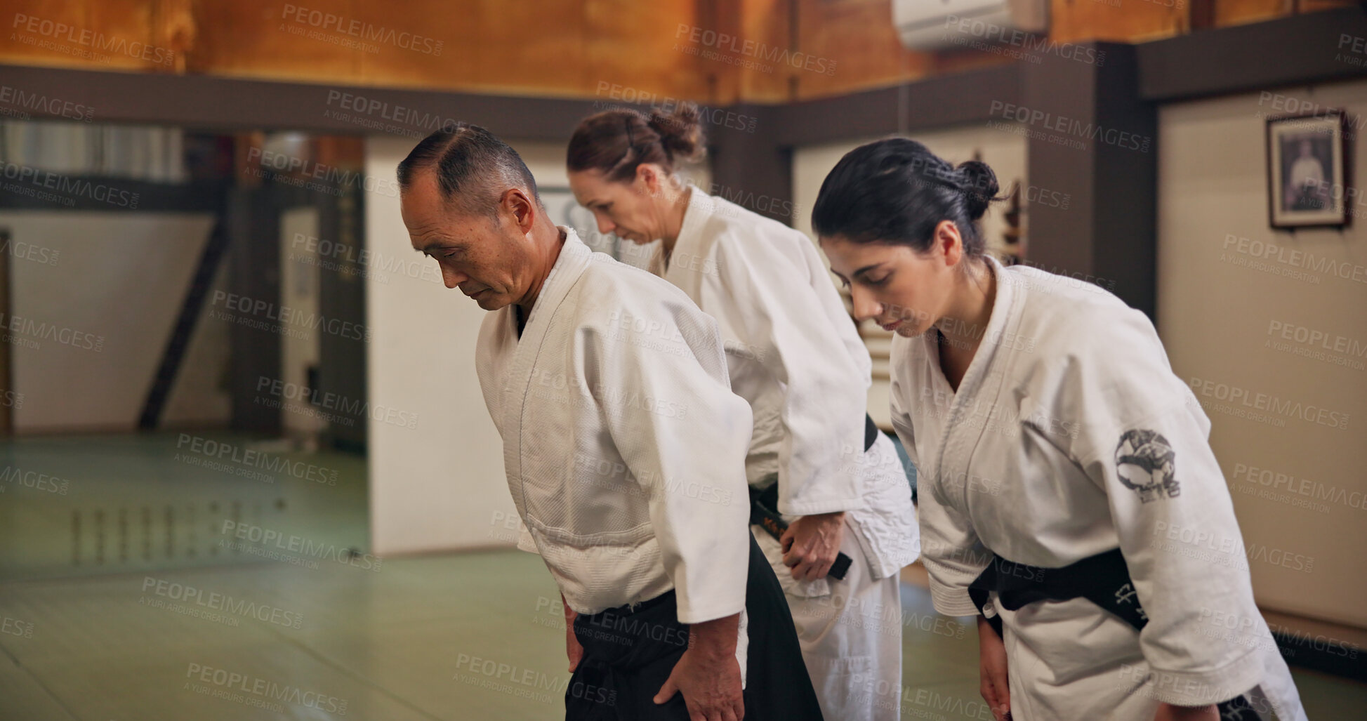 Buy stock photo Bow, greeting and students in martial arts studio for practice, training or self defense class. Culture, karate and group of people with respect or etiquette gesture to master in dojo for honor.