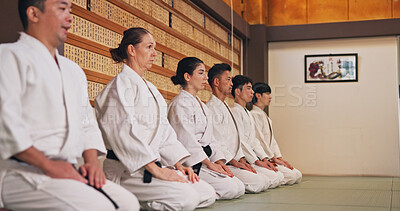 Buy stock photo Discipline, kneeling and people in martial arts studio for practice, training or self defense class. Culture, karate and group of students with respect, honor or etiquette gesture to master in dojo.