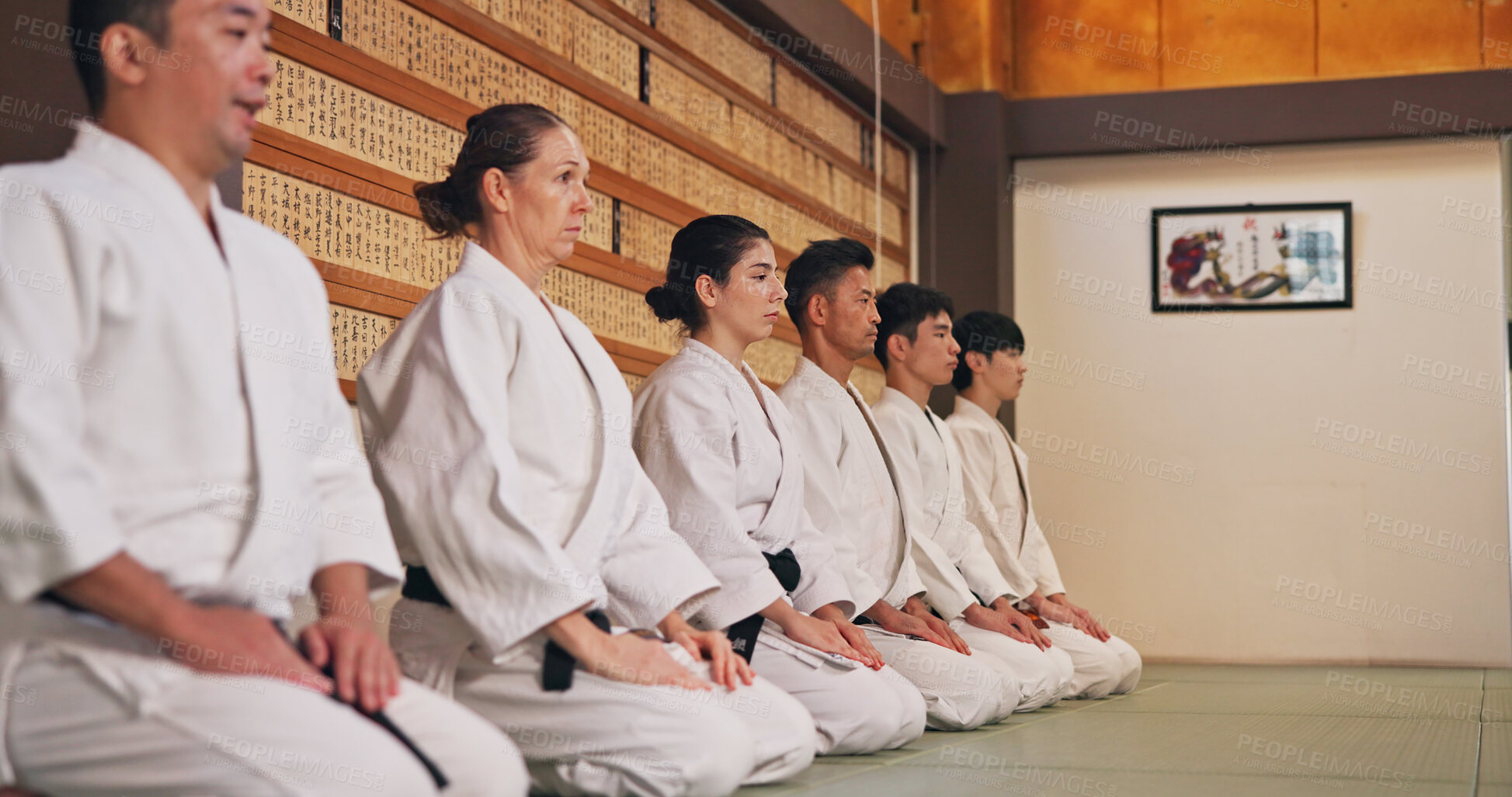 Buy stock photo Discipline, kneeling and people in martial arts studio for practice, training or self defense class. Culture, karate and group of students with respect, honor or etiquette gesture to master in dojo.