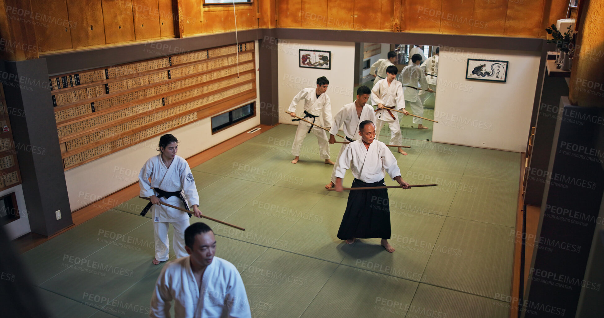 Buy stock photo Dojo, group class and Aikido training in gym with wood sword Japanese martial arts and fight exercise in wellness studio. Learning, sport and bamboo weapon with people and strike practice for defence