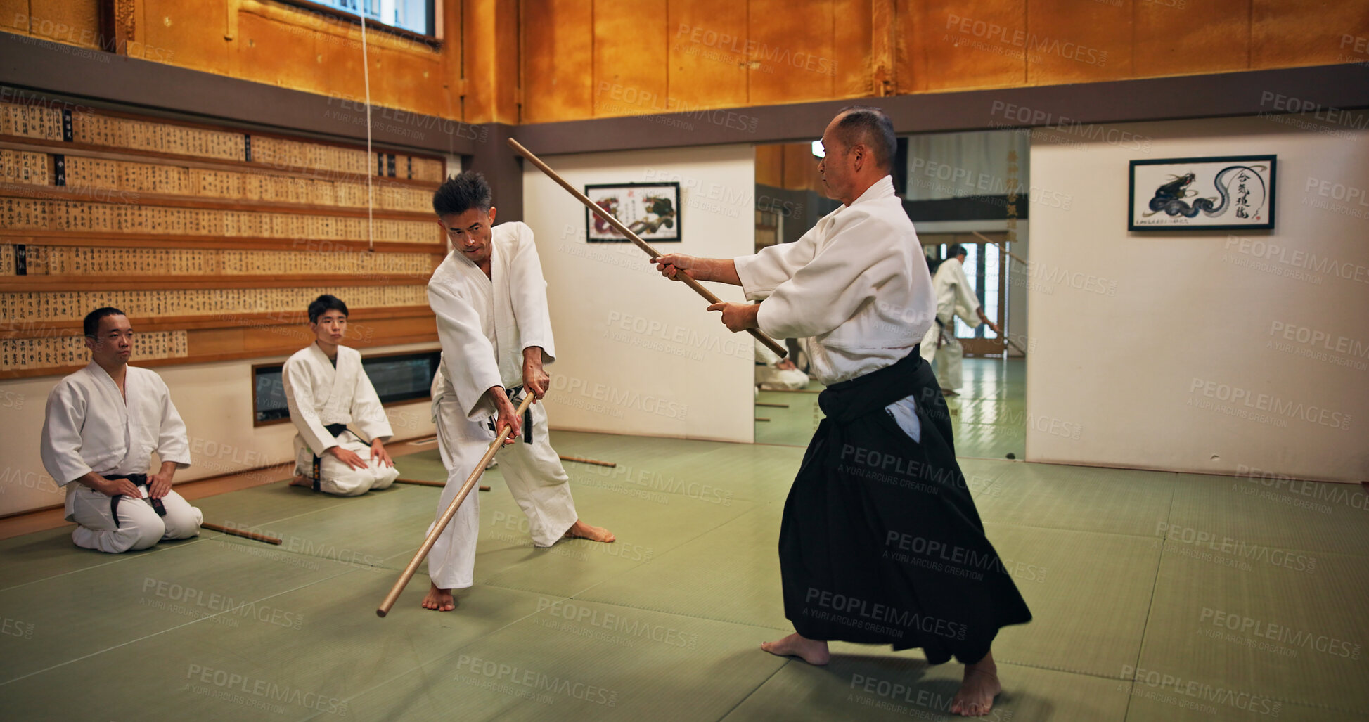 Buy stock photo Dojo, class and mentor in Aikido training in gym with wood sword Japanese martial arts and fight exercise in wellness studio. Learning, sport and weapon with people and strike practice for defence