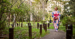 Happy, asian woman and walking with kimono in park for travel, sightseeing or journey on path. Japan, female person or tourist with smile or fashion for tradition, culture or heritage in nature