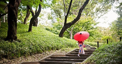 Buy stock photo Kimono, park and umbrella with woman on steps to explore green location for sightseeing or tourism. Back, fashion and travel with person walking in nature of Japan for culture, holiday or vacation