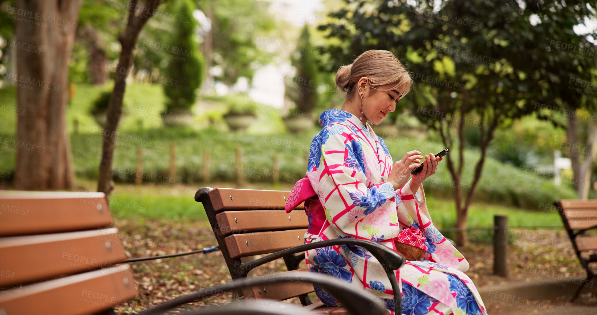 Buy stock photo Relax, park and Japanese woman with phone for social media, scroll message and reading ebook on internet. Asian girl, mobile and outdoor on bench for blog, chat app and traditional kimono for culture