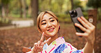 Selfie, park and woman in nature, peace sign and happy for memory on vacation, travel and kimono. Outdoor, photography and gesture for profile picture, digital and photo for social media in Japan