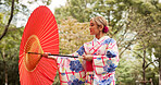 Park, umbrella close and Japanese woman with fashion, thinking and travel with smile in woods. Street, kimono and parasol with walking, outdoor and journey with style and traditional dress in nature