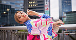 Asian woman, portrait and dancing with kimono in city for performance, tradition or Kpop culture in an urban town. Japan, female person or dancer with fashion, dress or style for art on Tokyo bridge