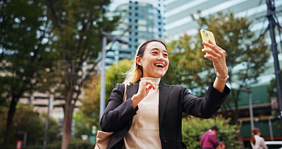 Buy stock photo Business woman, video call and phone in city with smile, contact and networking with legal career in street. Person, happy and corporate lawyer with smartphone for good news, deal or travel in Japan