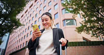 Buy stock photo Business woman, smartphone and luggage on travel in city with contact, happy and low angle on urban sidewalk. Person, phone and corporate lawyer with booking taxi, networking and baggage in Japan