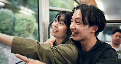 Buy stock photo Vacation, couple and travel in cable car for tourism, holiday and pointing for sightseeing in Japan. Smile, man and woman in transport for adventure, hug and trip together on journey to Mount Takao