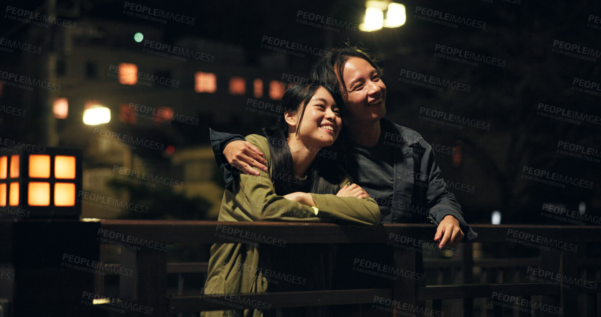 Buy stock photo Bridge, couple and happy at night with hug for bonding, sightseeing and explore for fun in Japan. People, relationship and smile outdoor on evening date for fresh air, support and care as lovers