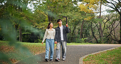 Buy stock photo Asian couple, holding hands and travel to park for holiday, pointing or sightseeing together. Japanese man, woman and walk on date at garden outdoor for romantic connection, love or happy on vacation