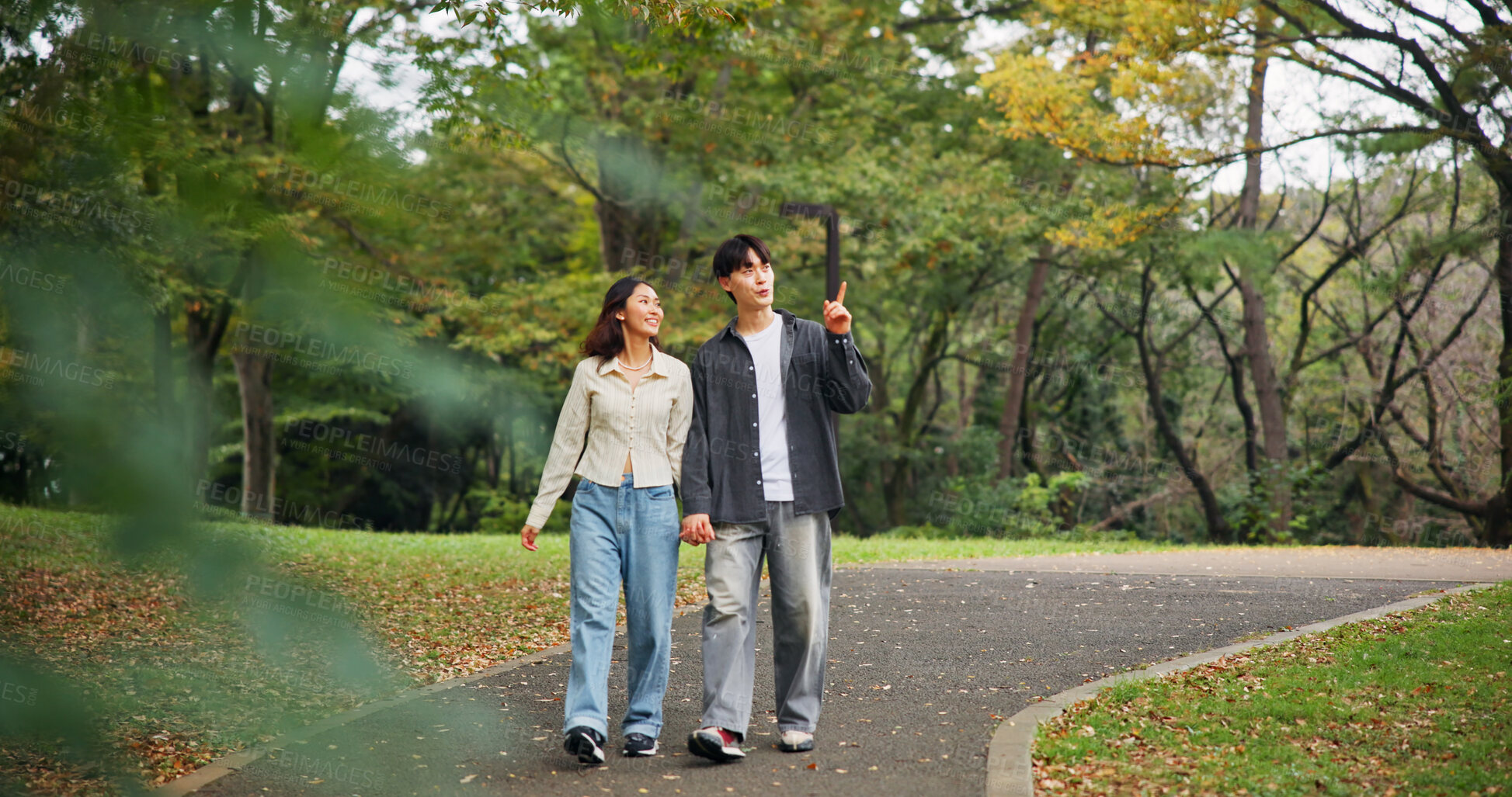 Buy stock photo Asian couple, holding hands and travel to park for holiday, pointing or sightseeing together. Japanese man, woman and walk on date at garden outdoor for romantic connection, love or happy on vacation