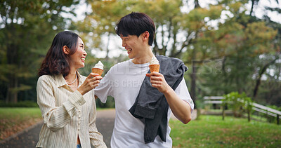 Buy stock photo Happy couple, date and walk in park with ice cream, bonding and funny story in Osaka. Japanese people, travel and outdoor with dessert snack for relationship development, journey and laugh for love