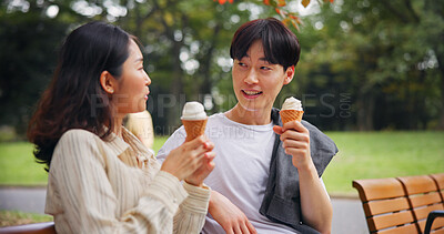 Buy stock photo Couple, date and relax in park with ice cream, bonding or share memory in Osaka. Japanese people, travel or outdoor with dessert snack for relationship development, weekend catch up or smile for love
