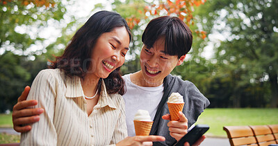 Buy stock photo Couple, phone or happy in park with ice cream, bonding or funny social media in Tokyo. Japanese people, laugh or outdoor with mobile for relationship development, comedy meme or dessert snack on date