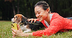 Selfie, nature and woman relaxing with dog for memory, social media or online post in woods. Happy, bonding and Japanese female person on grass with beagle puppy for photography picture outdoor.