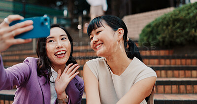 Buy stock photo Women, video call and friends with wave in city, stairs and contact with smile, outdoor and chat on web. People, together and smartphone with social network, hello and mobile app on steps in Japan