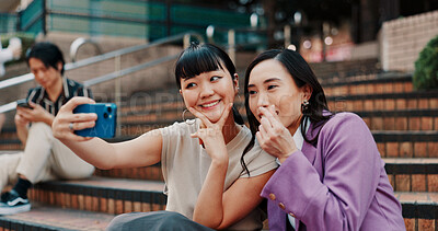 Buy stock photo Business women, selfie and together on stairs with smile for peace sign, partner or heart for post in city. People, friends and photography with laugh, funny and emoji for profile picture in Japan