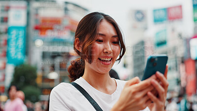 Buy stock photo Woman, phone and happy with travel in city, reading and check notification with chat, laugh or meme in street. Girl, smartphone and outdoor on metro sidewalk, smile and app for social media in Japan