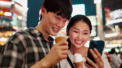 Buy stock photo Happy couple, ice cream and phone for travel, date or check notification with bonding, love or contact in city. People, man and woman on smartphone, smile or gelato on social media at night in Japan