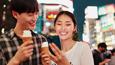 Buy stock photo Couple, ice cream and happy with phone for travel, date or notification with bonding, love or contact in city. People, man and woman on smartphone, laugh or gelato on social network at night in Japan