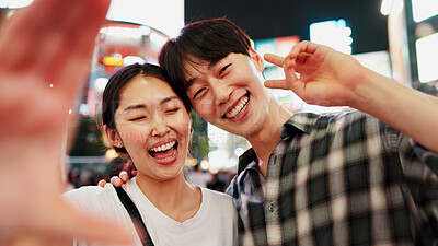 Buy stock photo Peace sign, night and selfie with couple in city together in Japan for bonding, love or tourism. Funny, photograph and smile of Japanese woman with man in urban town for holiday, travel or vacation