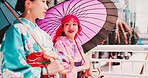 City, umbrella and girl friends in kimono walking on bridge for chat, morning travel or sightseeing together. Urban, fashion and Japanese women with traditional clothes, parasol or culture on commute