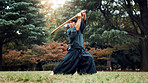 Wooden sword, Japanese man and outdoor in sports, exercise and training for martial arts or aikido. Male person, weapon and heritage for challenge, combat and practice as defense technique or bojutsu
