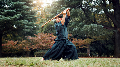 Buy stock photo Wooden sword, Japanese man and outdoor in sports, exercise and training for martial arts or aikido. Male person, weapon and heritage for challenge, combat and practice as defense technique or bojutsu