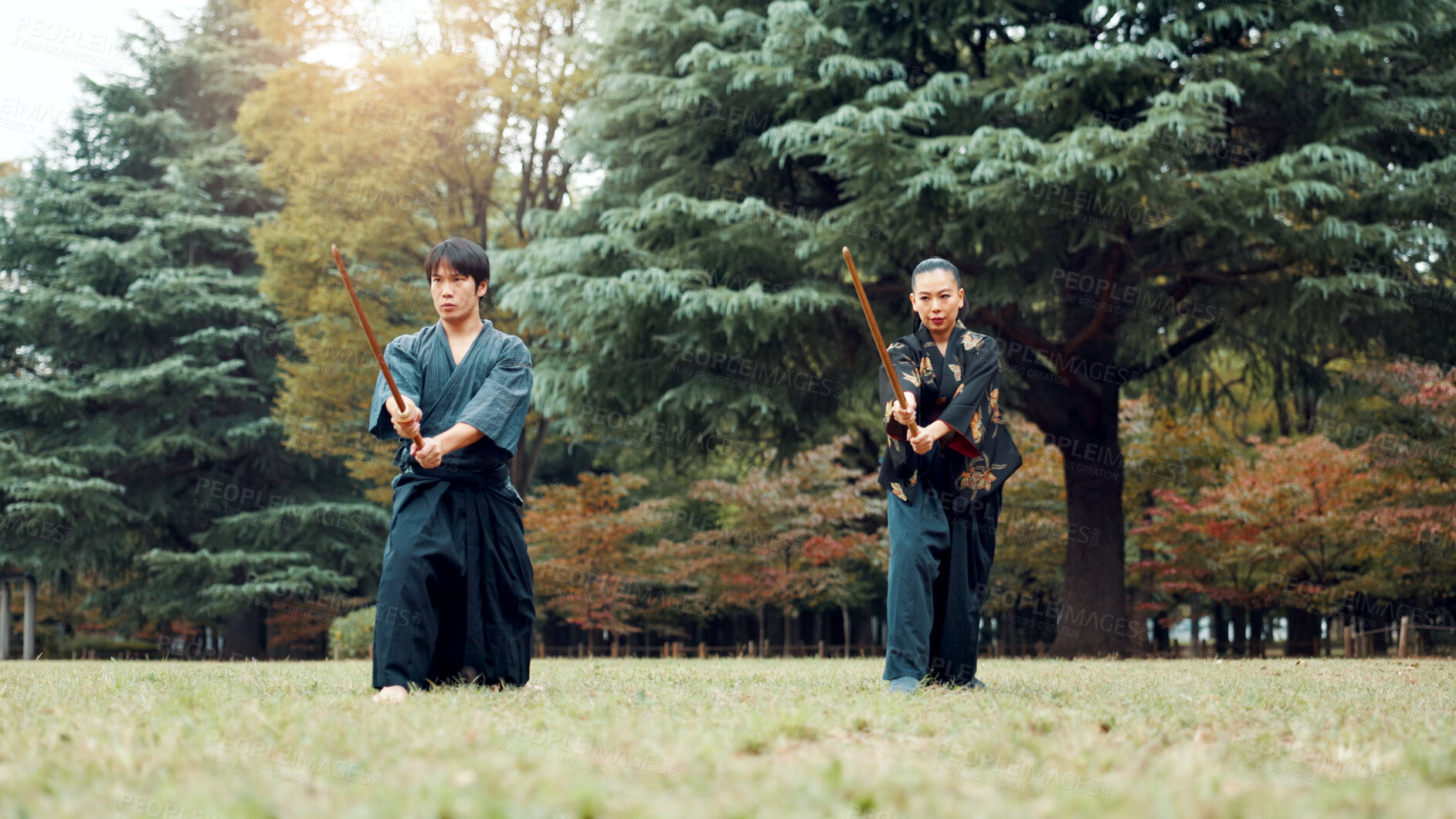 Buy stock photo Sword, martial arts and people in nature training together for aikido, fight coaching or outdoor samurai challenge. Warrior, Japanese man and woman in park for traditional bokken battle with wood