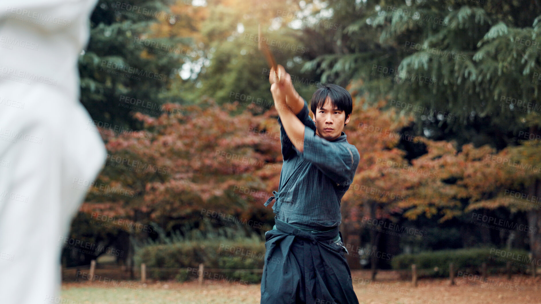 Buy stock photo Sword, martial arts and man in park training fight, coaching and learning with outdoor samurai challenge. Weapon, warrior and Japanese people sparring together in nature for traditional bokken battle