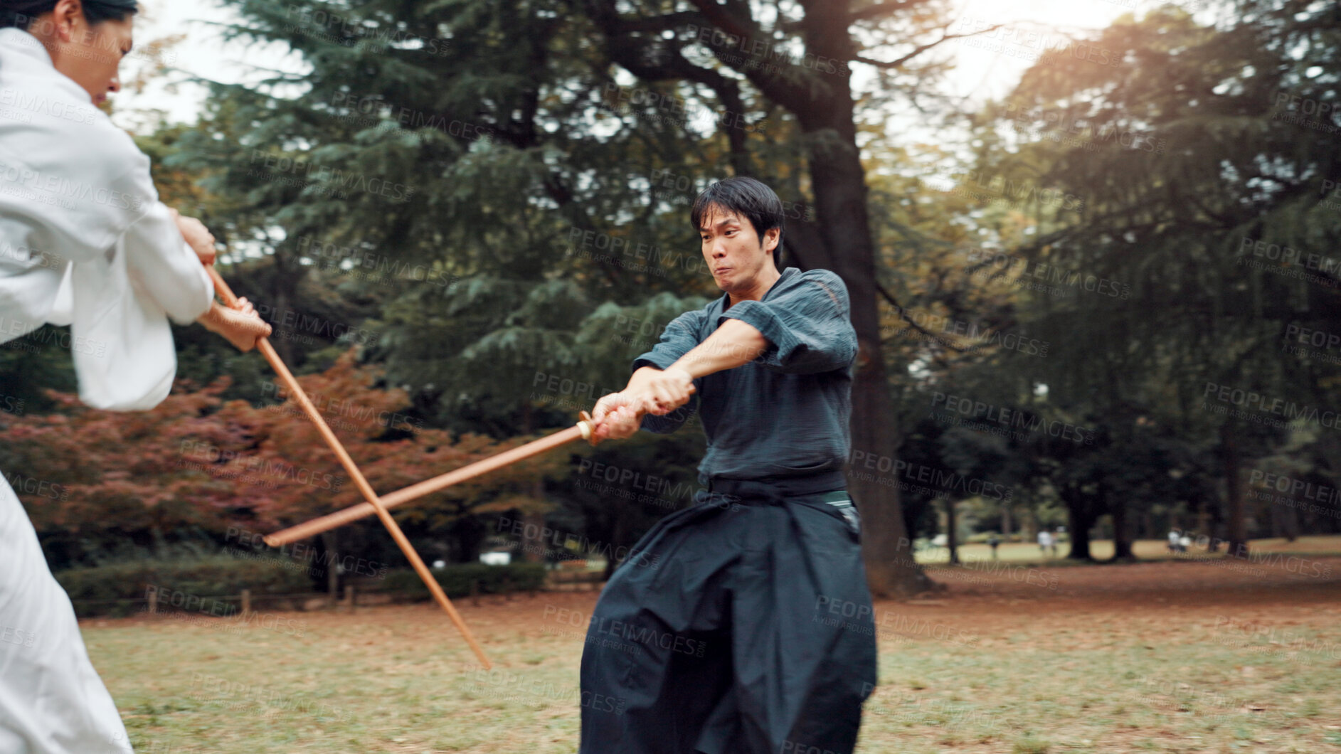 Buy stock photo Sword, martial arts and men in outdoor fight together for aikido training, coaching or samurai challenge in park. Weapon, warrior and Japanese people sparring in nature for traditional bokken battle.