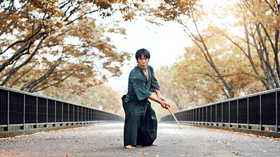 Buy stock photo Martial arts, Japanese man and wood sword outdoor with fight, battle and samurai training on road. Park, urban and challenge with bamboo weapon, kendo and warrior in autumn with traditional uniform