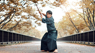 Buy stock photo Martial arts, man and wood weapon outdoor with fight, battle and samurai training on road. Park, urban and challenge with bamboo sword, kendo and warrior in autumn in Japan with forest and fighter