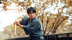 Martial arts, serious man and wood sword outdoor with fight, battle and samurai training on road. Park, urban and challenge with bamboo weapon, kendo and warrior in autumn in Japan and forest