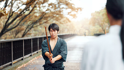 Buy stock photo Instructor, bamboo sword and Asian man in city for martial arts, Kendo practice and exercise. Culture, heritage and person with shinai and bokuto for skill, fight and traditional training in Japan
