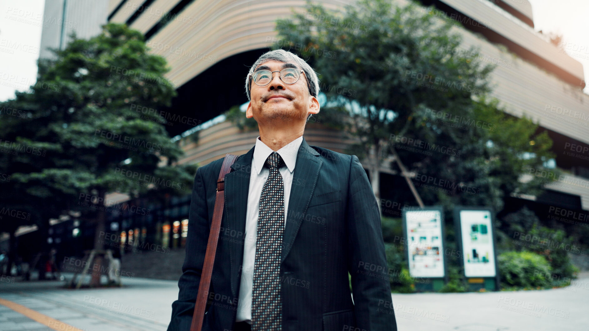 Buy stock photo Mature, business man and walking in city for morning commute, journey to work and travel with bag. Japanese professional, commuter and trip to job with sightseeing, urban town scenery and daydreaming