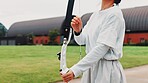 Archery, sport and hands with bow on field for shooting practice, martial arts tradition or getting ready. Japanese culture, person and equipment safety for kyudo, precision lesson or target training
