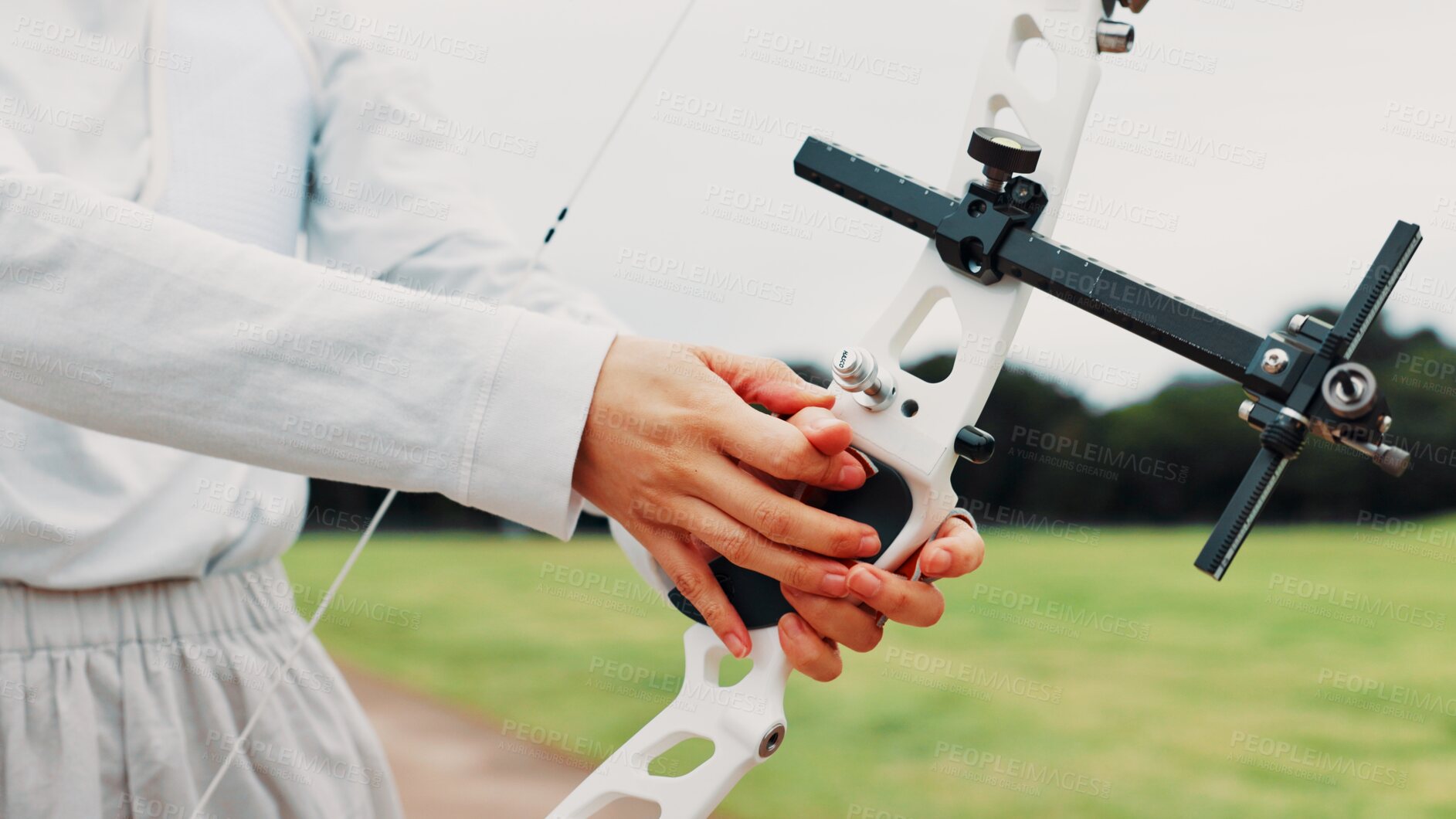 Buy stock photo Person, archery and hands at field for sport at shooting practice and training as athlete in Japan. Closeup, target and setup recurve bow or equipment for challenge, tournament and competition 