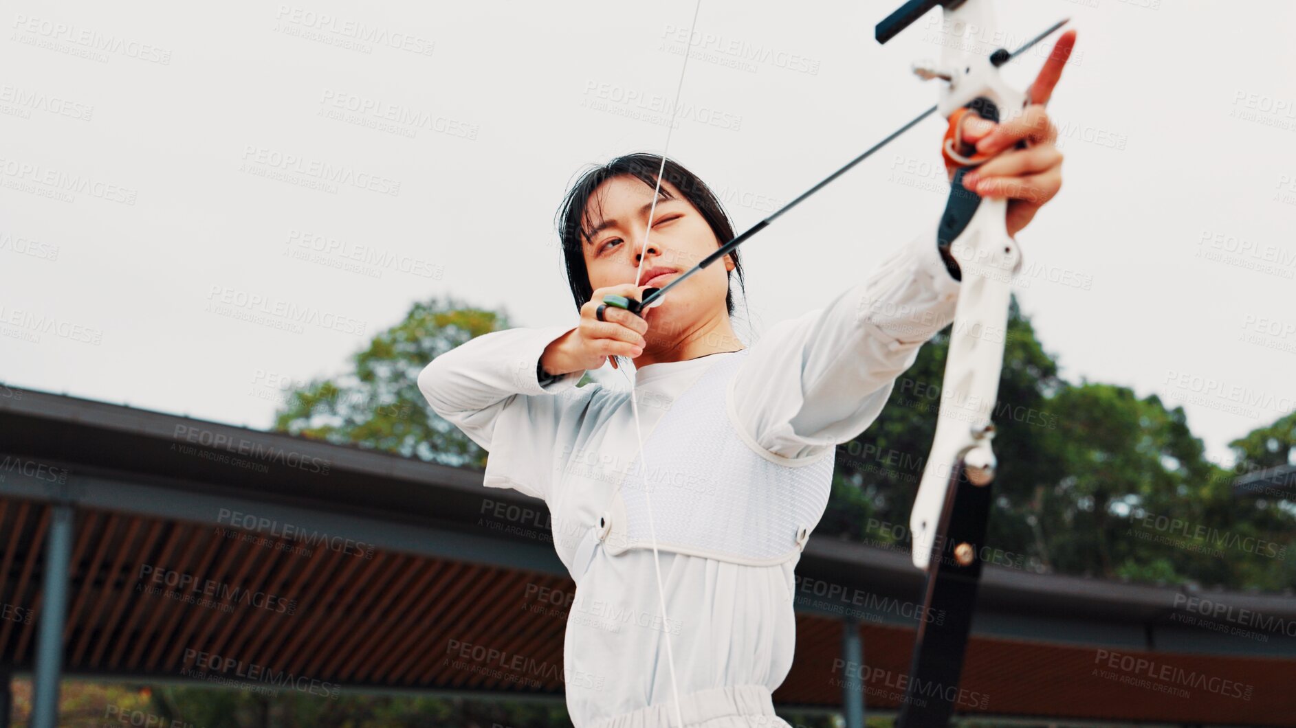 Buy stock photo Serious, training and woman with bow, aim and preparing for competition, equipment or outdoor for game. Contest, athlete and practice from tournament, skills and challenge for person, archer or Japan