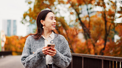 Buy stock photo Thinking, phone and happy woman at park for travel, text or message on app in Japan. Smile, mobile and Asian person outdoor for dream, planning vacation and post on social media profile on internet