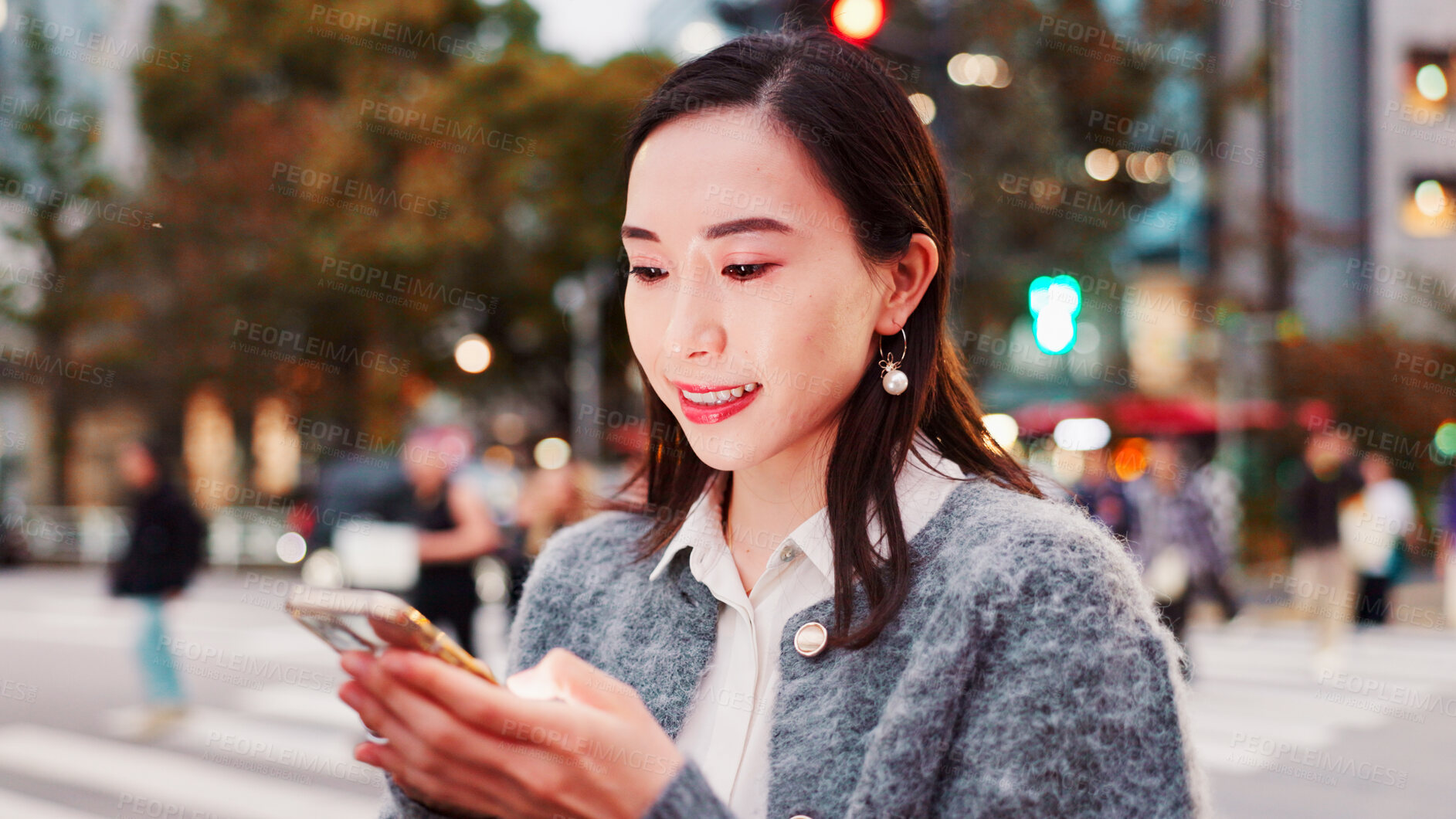 Buy stock photo Smile, phone and Asian woman in city for reading text, message or travel blog on holiday. Happy, mobile and Japanese person on street for chat, communication and post on social media profile at night