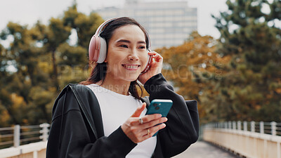 Buy stock photo Happy, woman and headphones with phone in city of listening to music, fitness podcast and social media. Athlete, mobile app and streaming radio for exercise routine, training website and Japan bridge