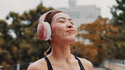 Buy stock photo Headphones, relax and running with Japanese woman in city for health, streaming and fitness podcast. Wellness, cardio and training with person listening to music in Japan for workout and marathon