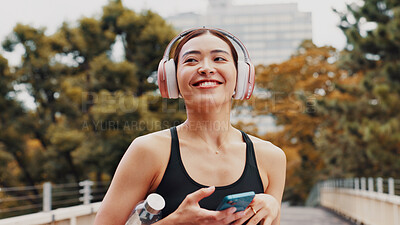 Buy stock photo Thinking, woman and headphones with phone in city, listening to music and fitness podcast. Female athlete, mobile and streaming radio with exercise routine, training website and break on Japan bridge